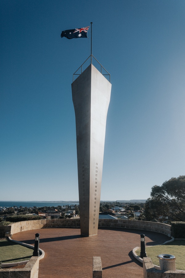 Tall coastal memorial with the Australian flag above it